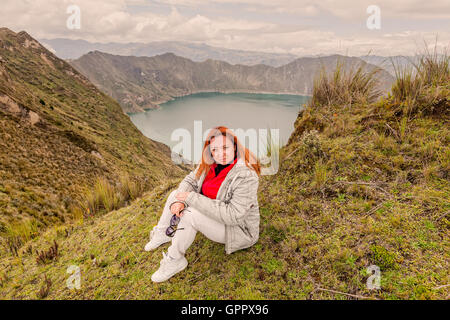Lächelnde blonde Jugend Frau stehen in der Nähe von Kratersee Quilotoa, Ecuador, Südamerika Stockfoto