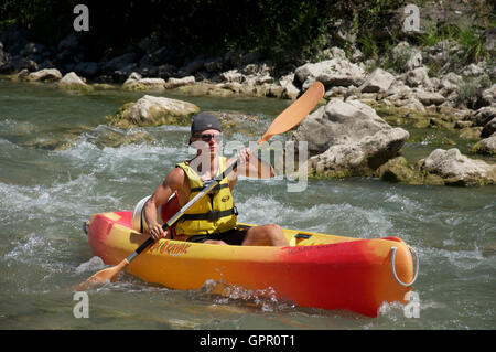 Tourismus, Tourist, Wassersport. Ein junger Mann Kanu die felsigen schnellen fließenden turbulenten Gewässern des Flusses Drôme. In der Nähe von Saillans, La Drôme, Frankreich. Stockfoto
