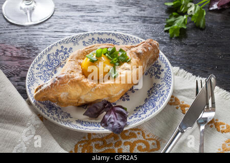 Khachapuri auf Teller mit Kräutern Stockfoto