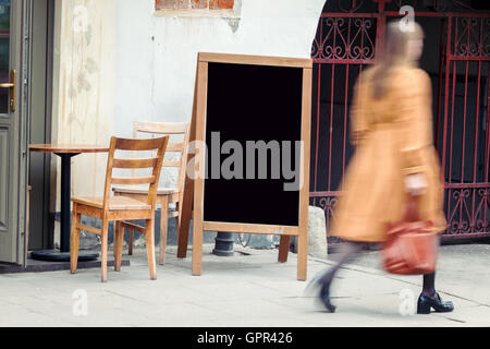 Leeres Restaurant Tafel auf der Straße mit verschwommenen Frau Fußgängerzone vorbei Stockfoto