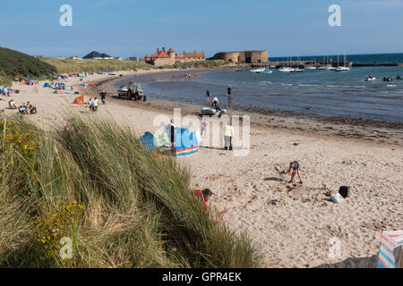 Beadnell-Strand und die Bucht mit dem Hafen und Kalk Öfen im Hintergrund, Northumberland Stockfoto