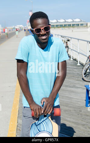 Young African American Mann mit seinem skateboard Stockfoto