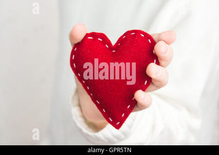 Weibliche Hand mit roten Herzen auf weißem Hintergrund, Nahaufnahme Stockfoto