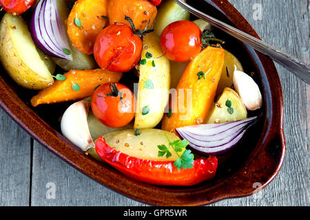 Rustikalen Ofen gebackenes Gemüse mit Gewürzen und Kräutern in Auflaufform hautnah, vegetarisches Bio Herbst Menü Stockfoto