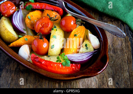 Rustikalen Ofen gebackenes Gemüse mit Gewürzen und Kräutern in Auflaufform hautnah, vegetarisches Bio Herbst Menü Stockfoto