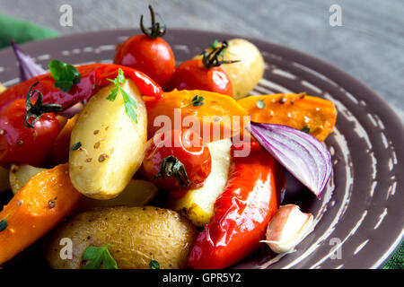 Rustikalen Ofen gebackenes Gemüse mit Gewürzen und Kräutern auf Platte hautnah, vegetarisches Bio Herbst Menü Stockfoto