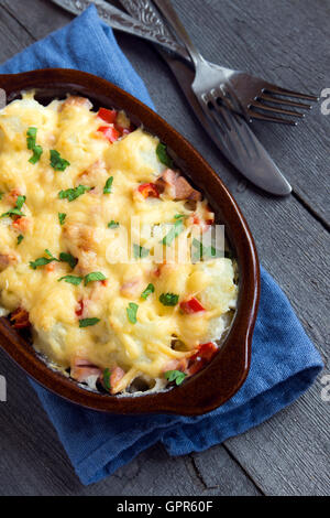 Blumenkohl und Käse überbacken in Auflaufform auf rustikalen hölzernen Hintergrund Stockfoto