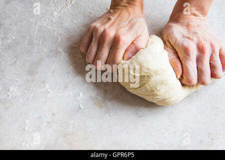 Händen kneten Teig auf Schneidebrett für hausgemachte Backwaren Stockfoto