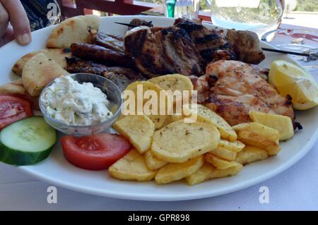 Teller mit einer Mischung-Gill mit Apfel Pommes Frites und Tomaten. Stockfoto