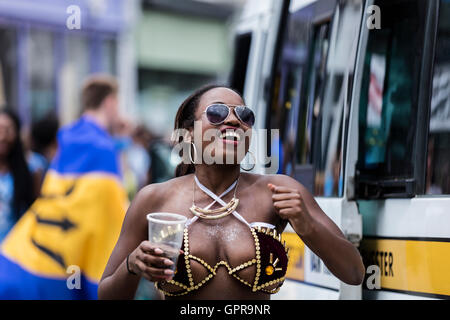 Schwarze Afro-Karibische Frau mit Sonnenbrille, die Spaß am Karneval von Notting Hill im Westen Londons Stockfoto