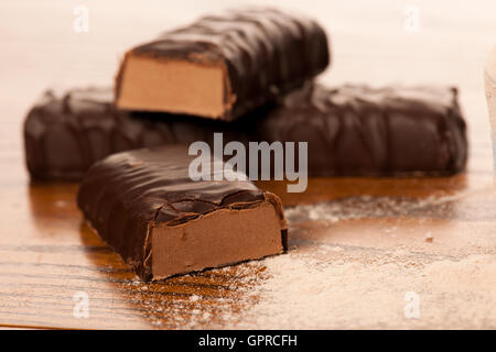 Whey Protein Pulver und Schokolade Proteinriegel auf hölzernen Hintergrund. Stockfoto