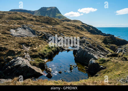 Ein Felsen-Pool auf der Strecke von Glen Shellesder Guirdil Bay mit Blutstein Hügel in der Ferne, Isle of Rum, Scotland, UK. Stockfoto