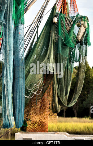 Netze hängen von dem Boom auf einem Garnelen-Boot entlang Jeremy Creek im Dorf McClellanville, South Carolina. Stockfoto