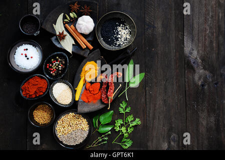 Gewürze und Kräuter auf dunklem Holz mit textfreiraum für Text. Essen und Küche Zutaten Stockfoto