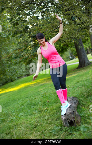 Fitness Mädchen Spaß balancing auf einem Baumstamm Stockfoto
