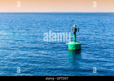 Grüne Navigations Boje Markierung mit Sonnenkollektoren im Meer Stockfoto