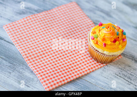 Cupcake auf rot karierte Serviette. Stockfoto