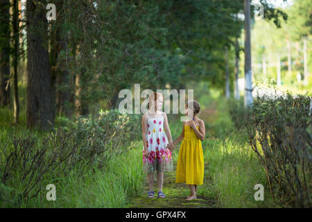 Zwei kleine süße Mädchen gehen und sprechen im Park. Stockfoto