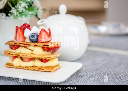 Mille Feuille mit Tee-Set auf Tisch im Café. Stockfoto