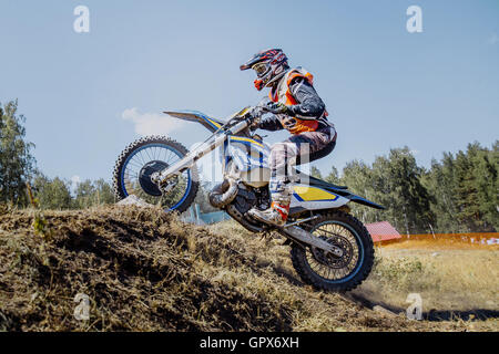 Sportler-Racer auf einem Motorrad fährt bergauf während Ural Cup in Enduro Stockfoto