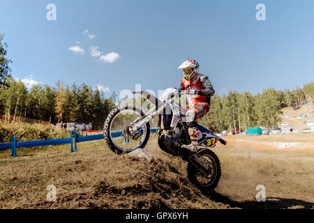 Racer auf einem Motorrad fährt bergauf auf Hinterrad während Ural Cup in Enduro Stockfoto