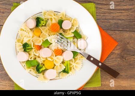 Farfalle mit Brokkoli, Karotten, Bohnen und Wurst Stockfoto