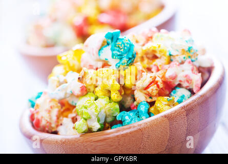 Farbe-Popcorn in Schalen und auf einem Tisch Stockfoto