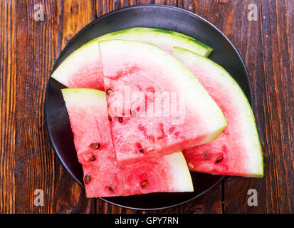 frische Wassermelone auf Teller und auf einem Tisch Stockfoto