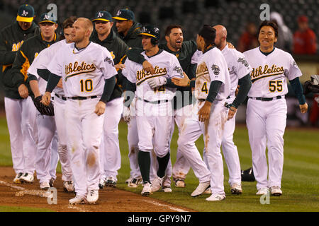 16. Mai 2011; Oakland, Kalifornien, USA;  Oakland Athletics Second Baseman Mark Ellis (Mitte) ist von Teamkollegen gratulierte, nach der Kollision mit des Spiels zu gewinnen RBI gegen die Los Angeles Angels während des zehnten Innings im Oakland-Alameda County Coliseum.  Oakland defe Stockfoto