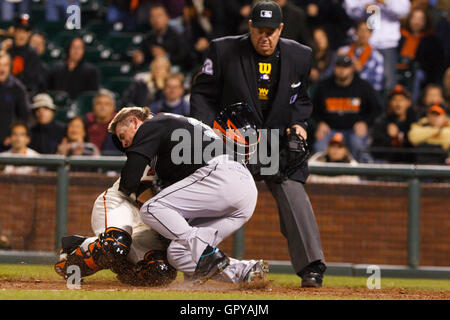 25. Mai 2011; San Francisco, CA, USA;  Florida Marlins Center Fielder Scott Cousins (rechts) kollidiert mit San Francisco Giants Catcher Buster Posey (links) um einen Lauf vor Schiedsrichter Joe West (22) während der zwölften Inning im AT&T Park zu erzielen. Florida defe Stockfoto
