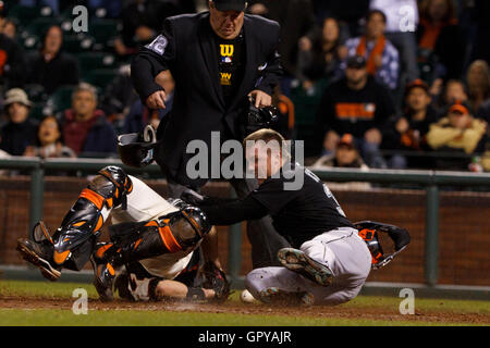 25. Mai 2011; San Francisco, CA, USA;  Florida Marlins Center Fielder Scott Cousins (rechts) kollidiert mit San Francisco Giants Catcher Buster Posey (links) um einen Lauf vor Schiedsrichter Joe West (22) während der zwölften Inning im AT&T Park zu erzielen. Stockfoto