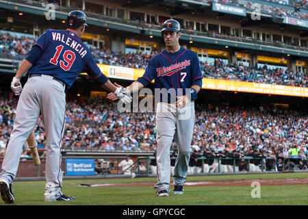 21. Juni 2011; San Francisco, CA, USA;  Minnesota Twins-Catcher, die Joe Mauer (7) durch Dritte Baseman Danny Valencia (19) gratulierte ist feiern nach scoring einen Lauf gegen die San Francisco Giants im ersten Inning im AT&T Park. Stockfoto