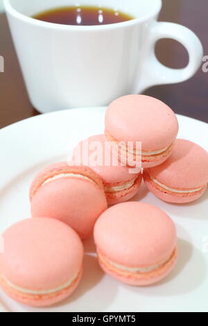 Rosa Macarons mit Tee im Hintergrund Stockfoto