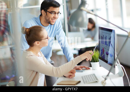 Zwei Kollegen diskutieren Daten auf Bildschirm Stockfoto