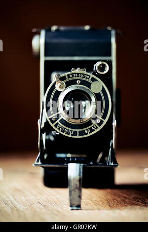 Nahaufnahme einer alten klappbaren Kamera auf einer rustikalen Holzoberfläche Stockfoto