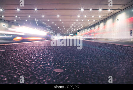 Schnelle Autos in einem modernen Tunnel bei Nacht Stockfoto