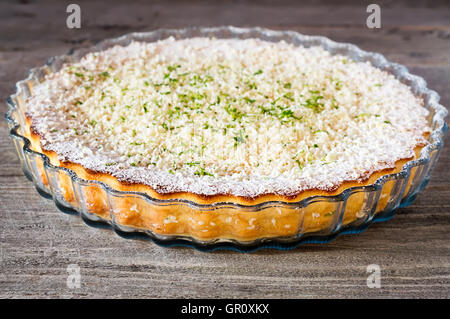 Seitenansicht der Zitrone, Limette, Kokosnuss unmöglich Torte mit weißer Schokolade Späne auf einem verwitterten Holztisch Stockfoto