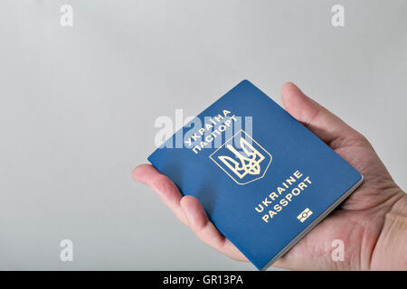 Hand, die ukrainischen biometrischen Pass auf weißem Hintergrund Closeup mit Textfreiraum Stockfoto