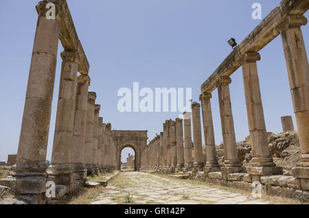 Spalten in Colonnaded Straße und nördlichen Tetrapylon im Hintergrund, antiken römischen Stadt Gerasa der Antike, moderne Jerash, J Stockfoto