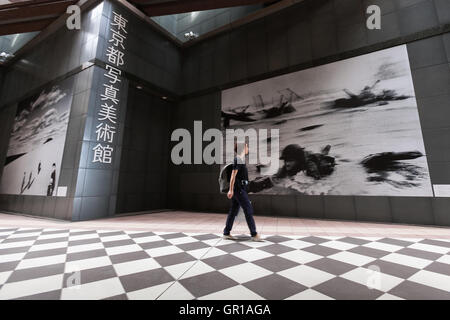 Ein Besucher geht vorbei an der Bilder auf dem Display außerhalb Tokio Fotografie Kunstmuseum in Ebisu Garden Place am 6. September 2016, Tokio, Japan. Früher bekannt als das Tokyo Metropolitan Museum of Photography, eröffnete neu das Museum seine Pforten in dieser Woche nach zweijähriger Renovierung. Auf Englisch ist es TOP MUSEUM genannt, da das Museum 18.812 Fotos von den besten japanischen und ausländischen Künstlern wie Ansel Adams, W. Eugene Smith und Gustave Le Gray enthält. © Rodrigo Reyes Marin/AFLO/Alamy Live-Nachrichten Stockfoto