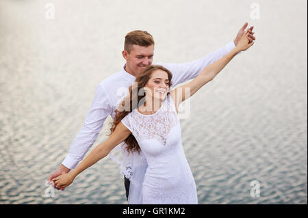 schöne junge Paare, die nahe dem See am Tag Hochzeit Stockfoto