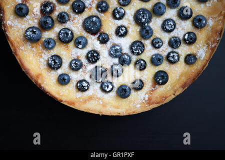 Frischen Heidelbeerkuchen auf hölzernen Hintergrund. Traditionelle italienische und amerikanische Gebäck, Beeren und Zucker Pulver auf Platte. Leckere dessert Stockfoto