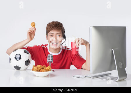 Porträt der jungen Mann mit Fußball und Brathähnchen Rundfunk lächelnd Stockfoto