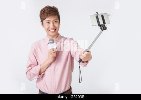 Lächelnde Jüngling mit a.microphone nehmen selfie Stockfoto