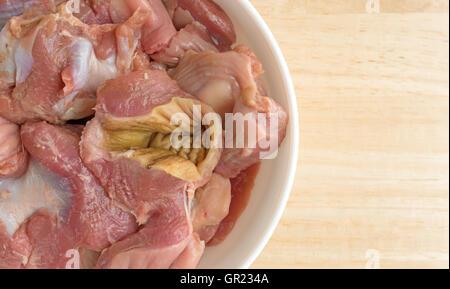 Enge Draufsicht einer Schüssel gefüllt mit frischem Huhn Mägen und Herzen auf einem Holztisch. Stockfoto