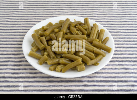Eine Portion organischen geschnittene grüne Bohnen auf eine gestreifte Tischdecke. Stockfoto