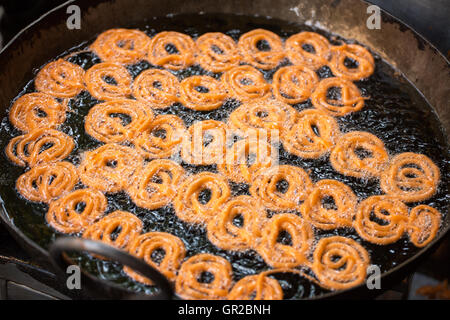 Nahaufnahme des köstlichen Jalebis Braten in Öl Pfanne am stall Stockfoto