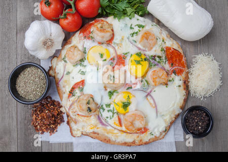 Ei-Pizza mit frischen Mozzarella und Zutaten Tomaten Garnelen Grünpfeffer Stockfoto