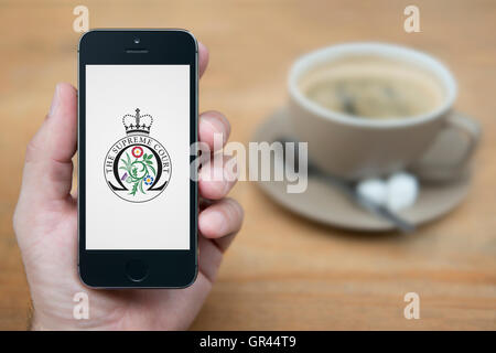 Ein Mann schaut auf seinem iPhone, der britischen Regierung oberste Gericht Kamm (nur zur redaktionellen Verwendung) anzeigt.