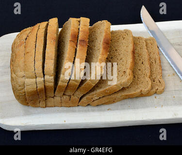 Frisch gebacken in Scheiben geschnittene braune Roggenbrot auf Schneidebrett. Stockfoto